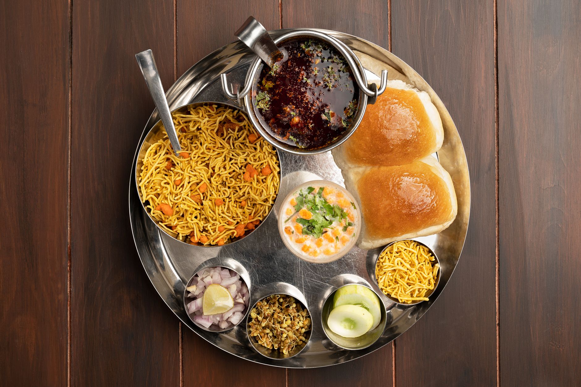 Regional Indian dishes — paratha, idli-sambar, rohu fish curry, dhokla — arranged as a flat-lay